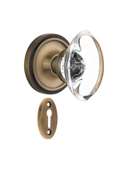 Classic Rosette Mortise-Lock Set with Oval Crystal Glass Knobs in Antique Brass.